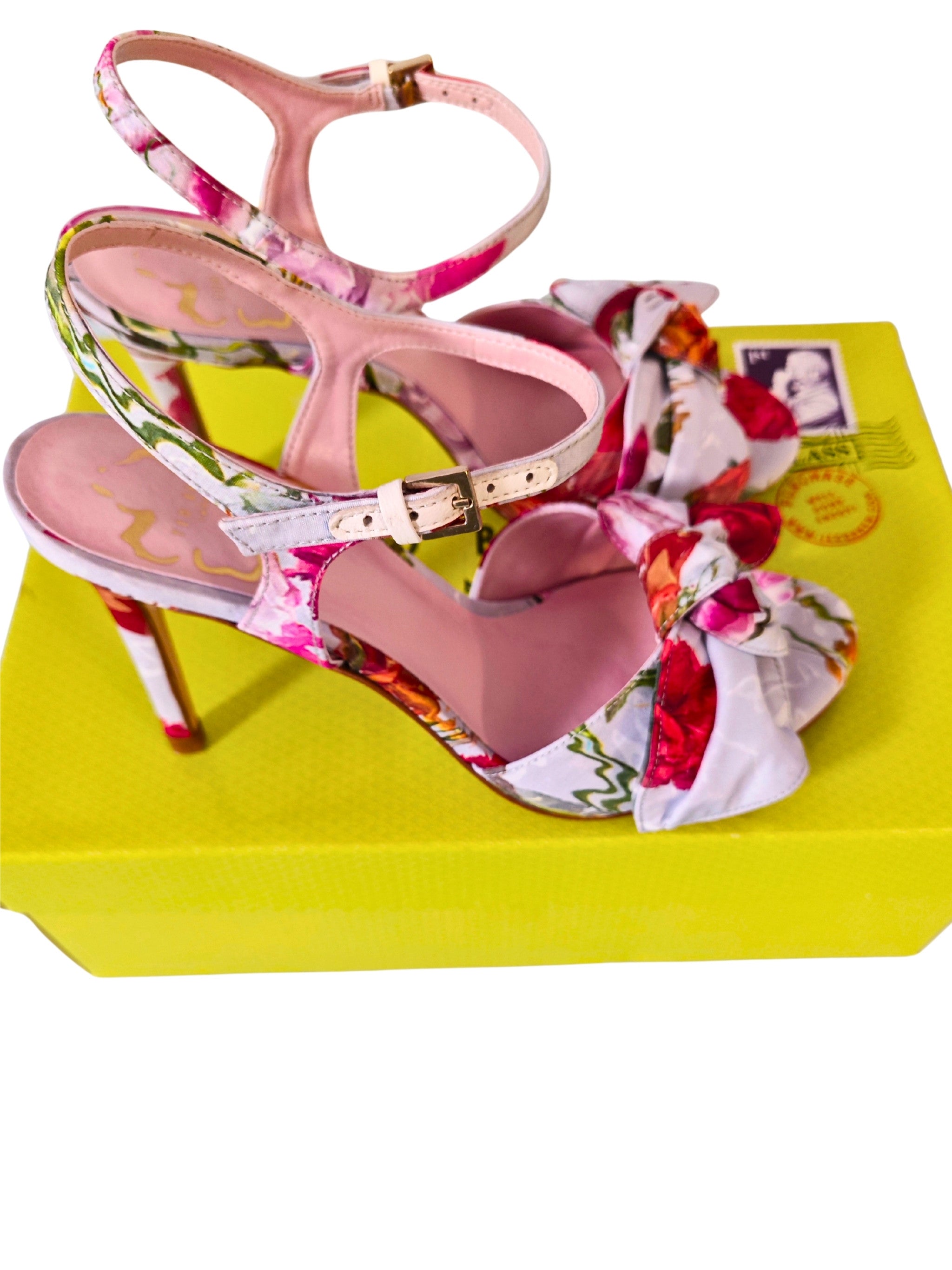 Par de sandalias Ted Baker NEELIA con estampado floral rojo y rosa sobre caja amarilla, correa tobillo dorada