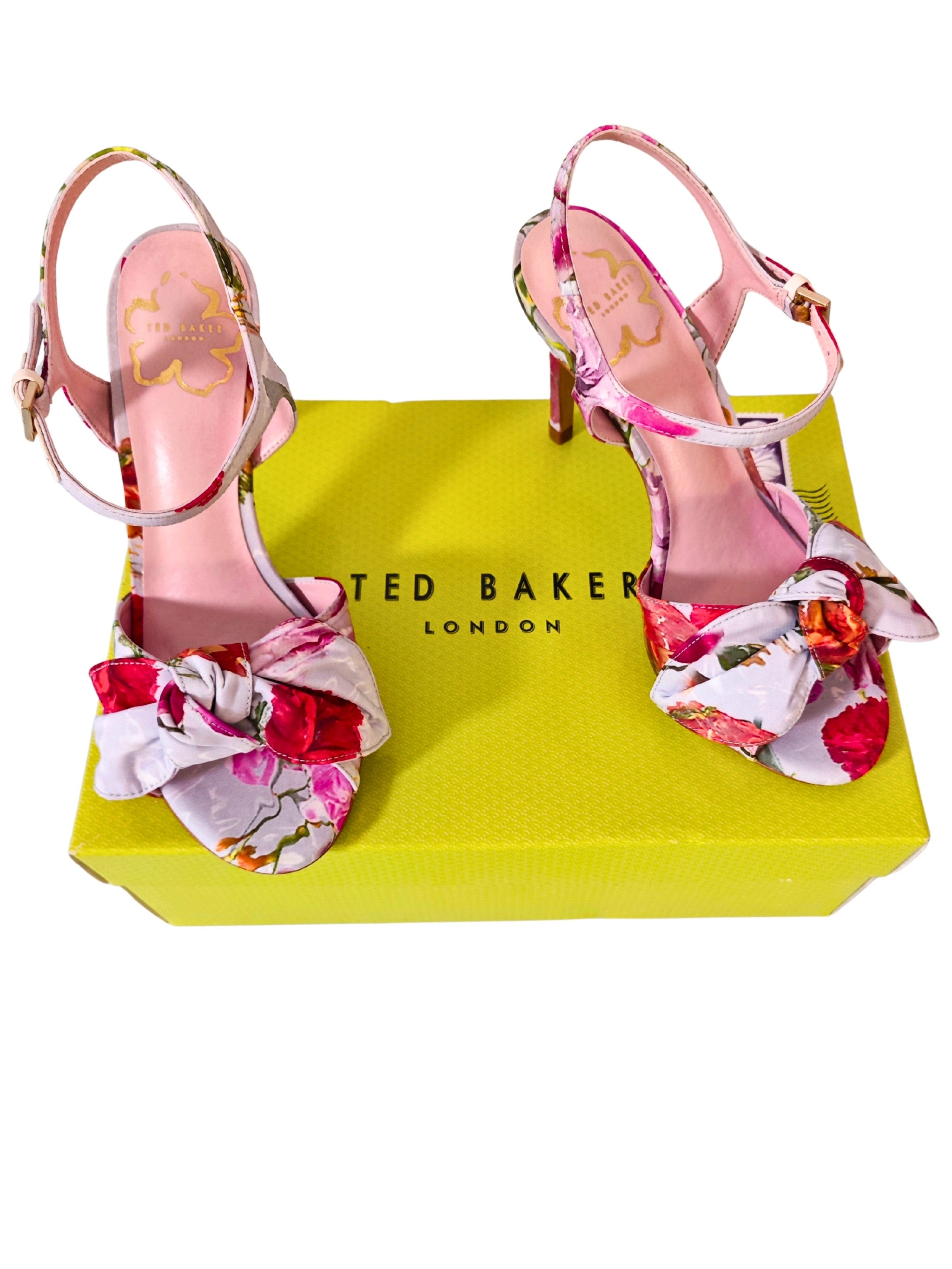 Sandalias Ted Baker London NEELIA vistas desde arriba, lazo floral doble y plantilla rosa con logo dorado, caja amarilla